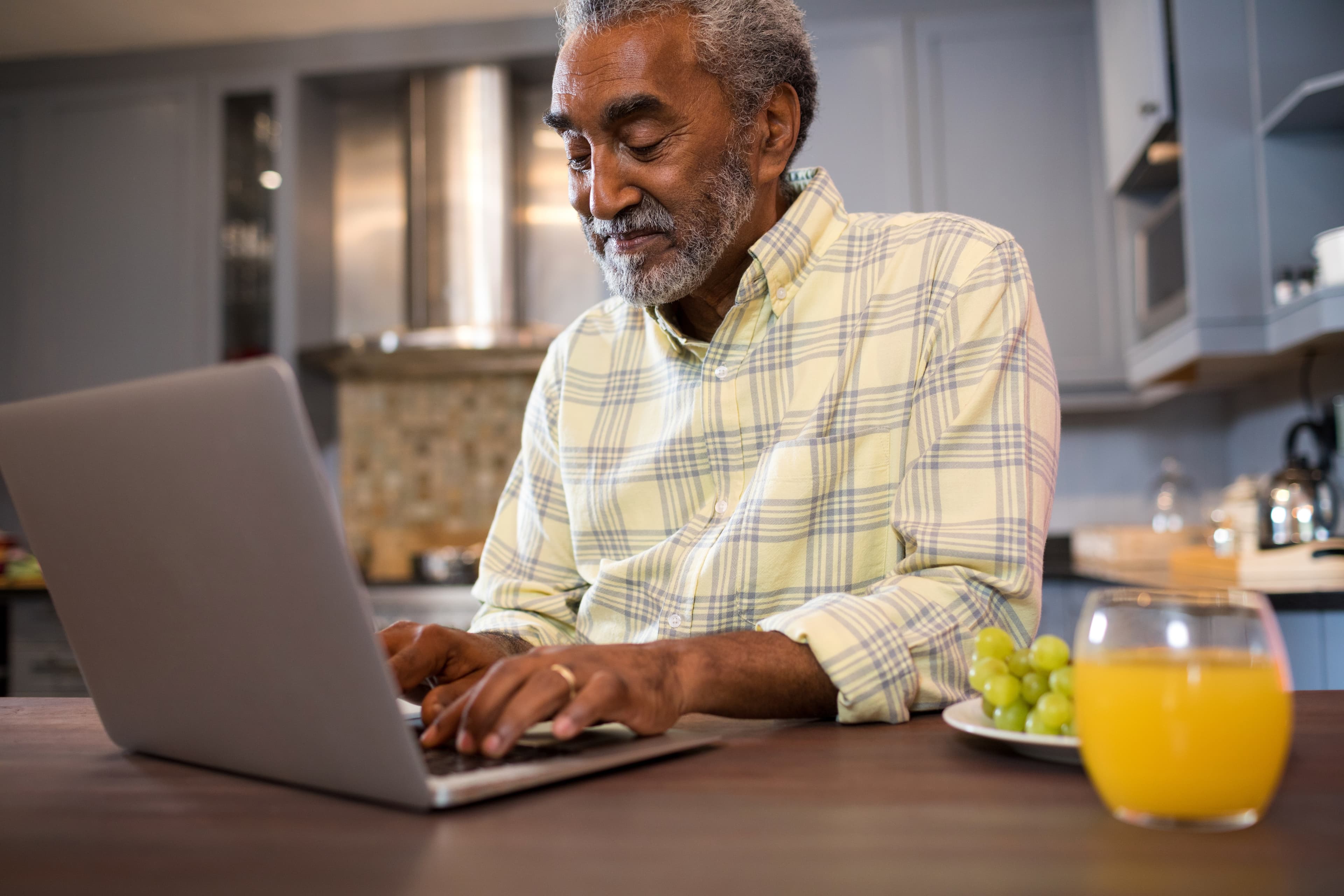 smiling elderly man looking at laptop