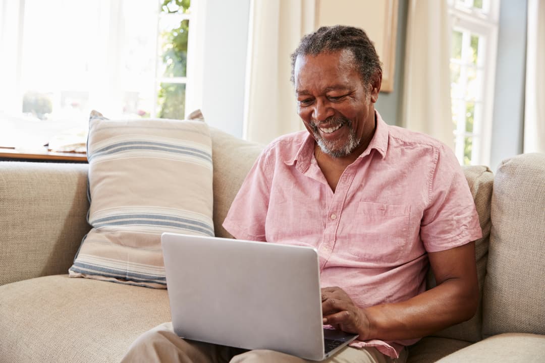 elderly man on the sofa looking at laptop
